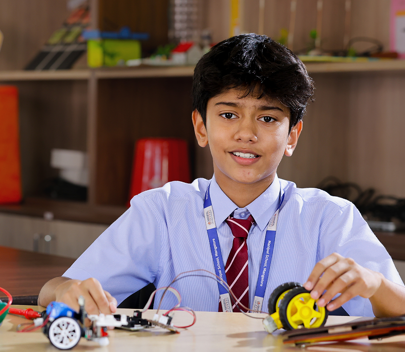 Middle school student building a robotics project at Manipal School