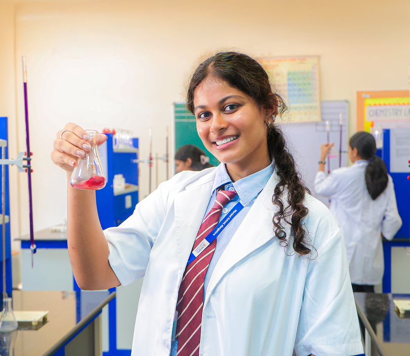 Secondary school student holding a flask in a chemistry lab at Manipal School